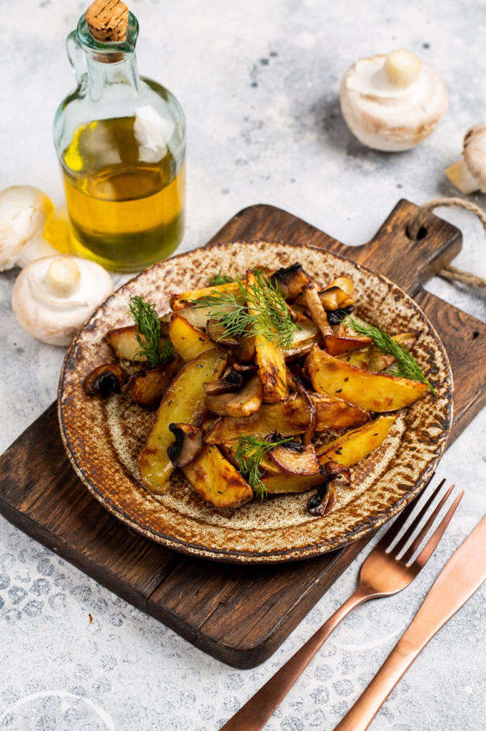 烤土豆角,配以新鲜莳萝,盛于质朴的陶瓷盘中,佐以一瓶橄榄油和整颗白蘑菇。